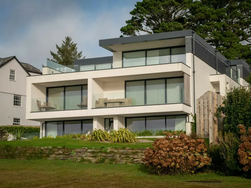 Modernes weißes Wohnhaus mit großen Fensterfronten und Garten