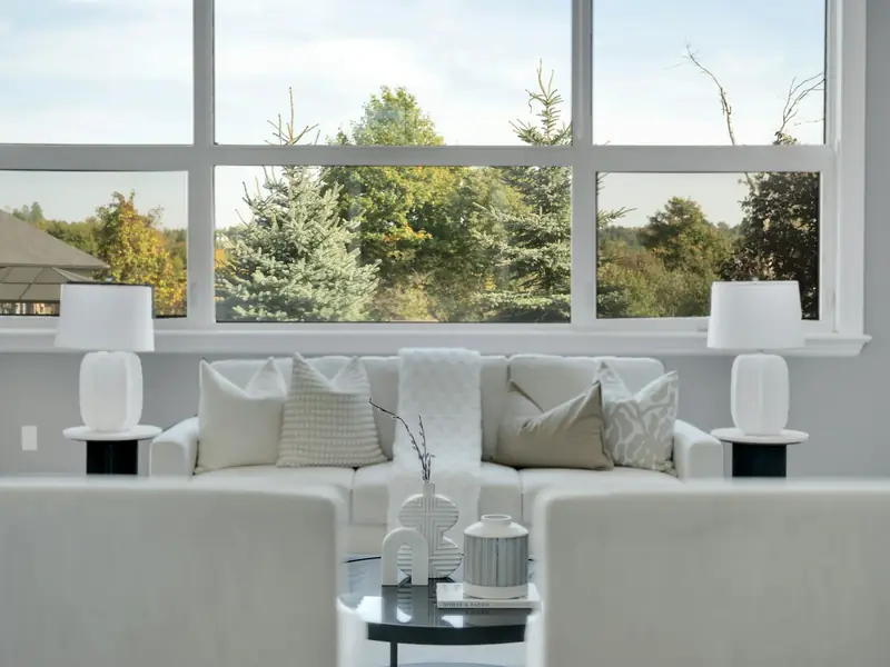 Helles Wohnzimmer mit großer, klarer Fensterfront und Blick ins Grüne